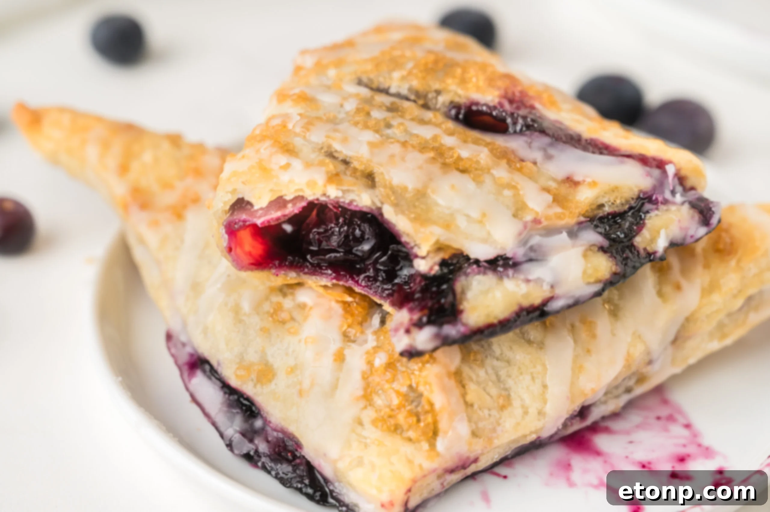 up close shot of  the Blueberry Turnovers on plate with a bite missing