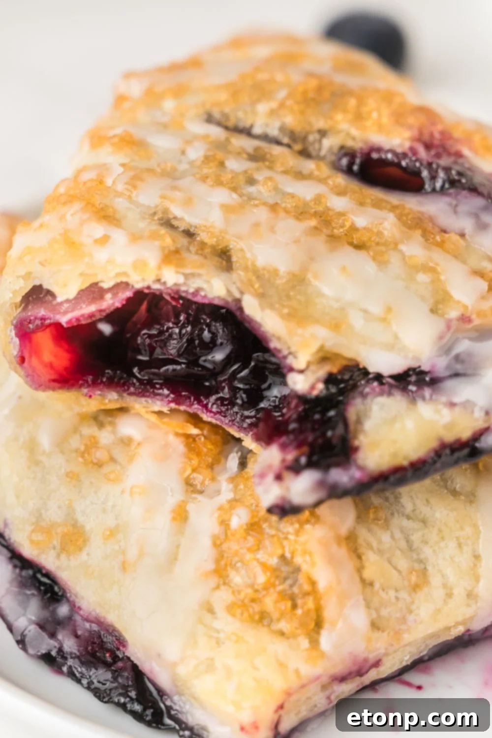 Blueberry Turnovers on a plate with one that has a bite taken out of it 