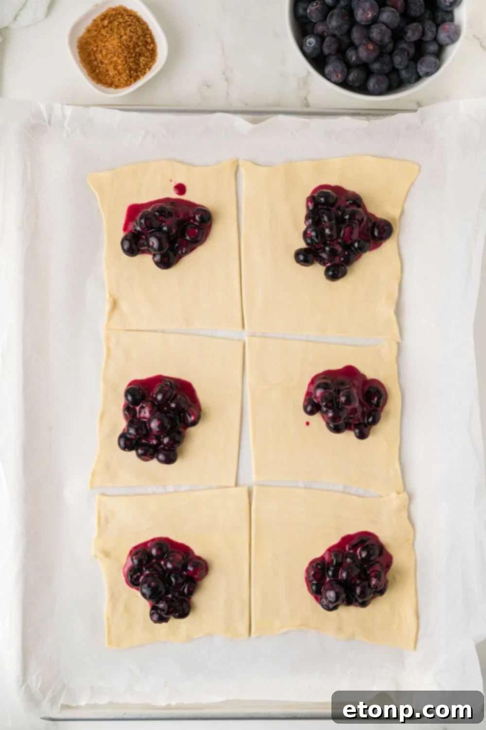 pastry cut in squares and topped with a blueberry filling for Blueberry Turnovers