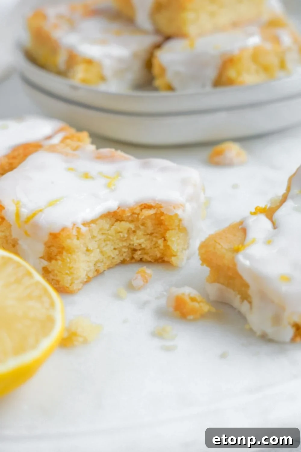 Soft and chewy lemon bars sliced and placed on table with a bite taken out of one of the bars