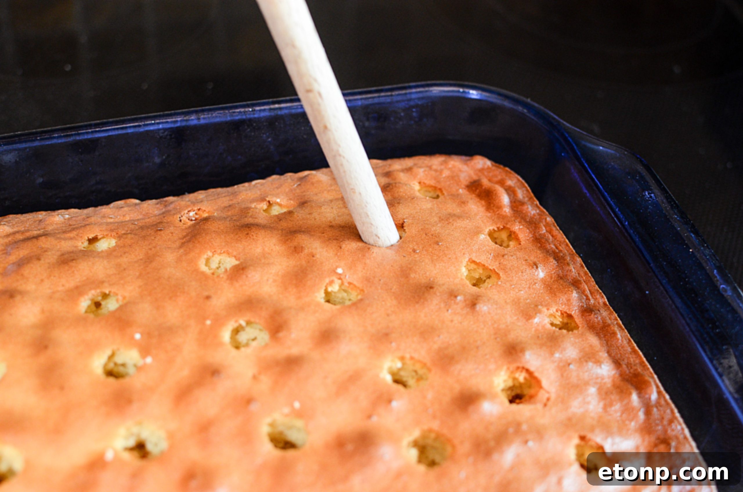 Overhead view of the entire Banana Lush Poke Cake garnished with fresh bananas and Nilla Wafers