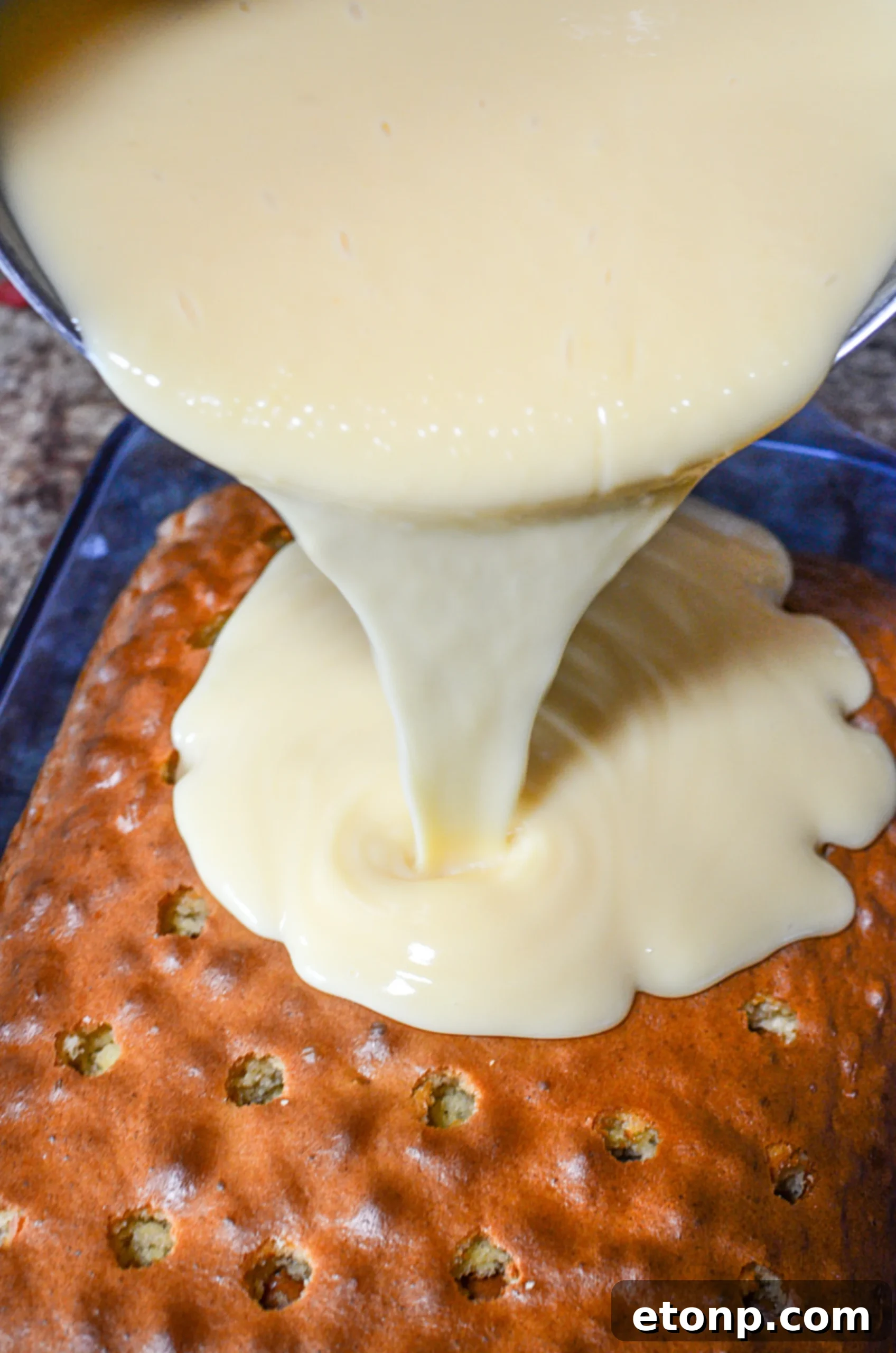 A close-up of the whipped cream topping on the Banana Lush Poke Cake with Nilla Wafers