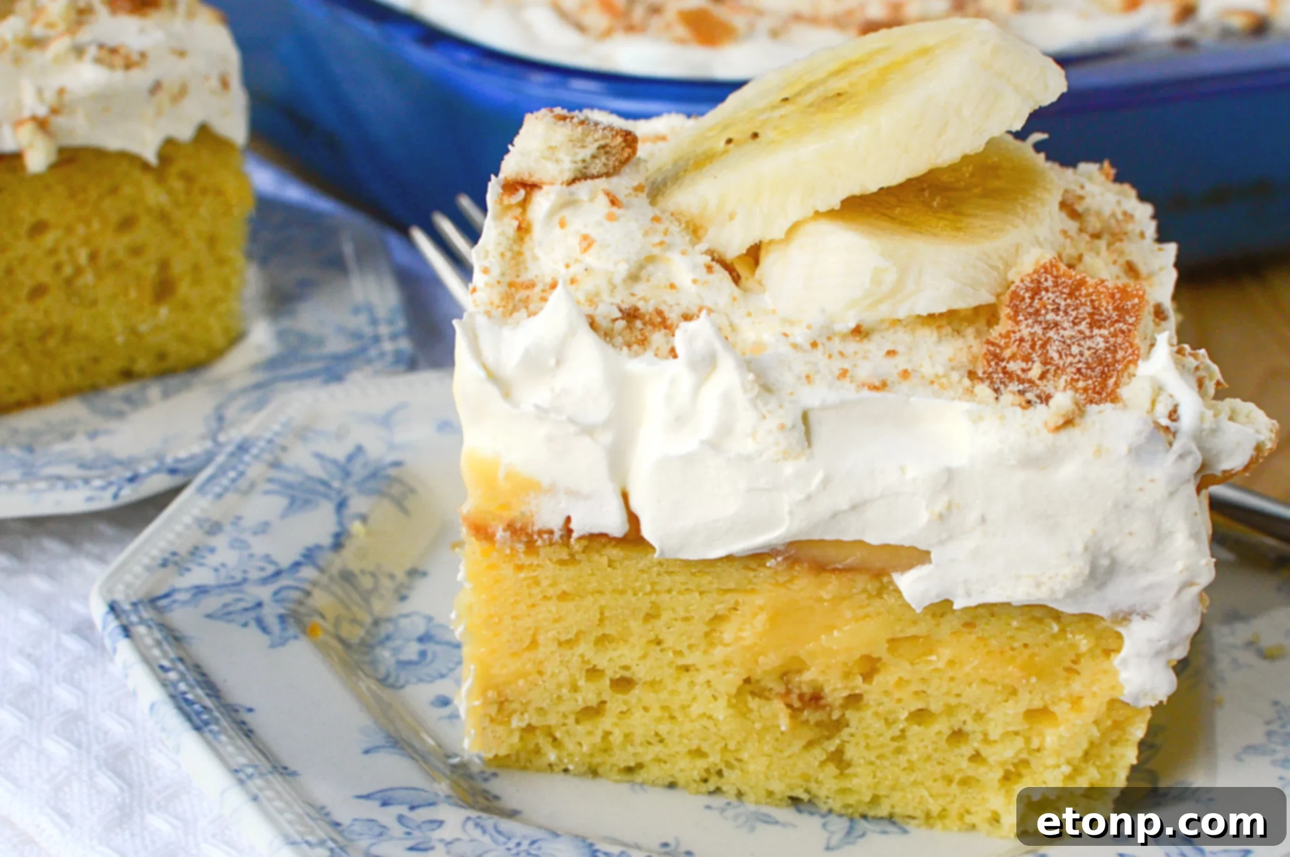 A large serving spoon scooping out a portion of Banana Lush Poke Cake