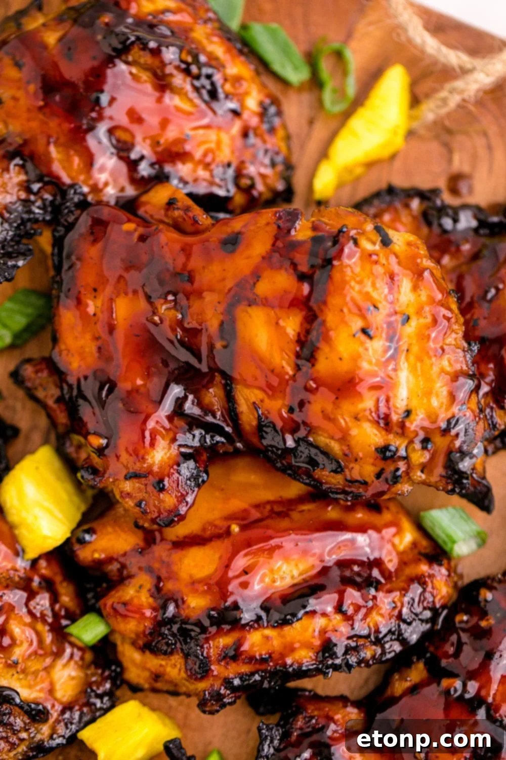 Huli Huli Chicken artfully arranged on a table with fresh diced pineapple, inviting a taste of the tropics