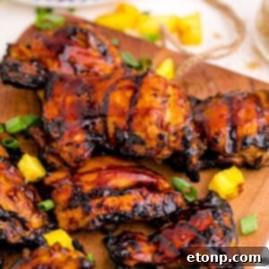 Huli Huli Chicken on a cutting board with pineapple on table