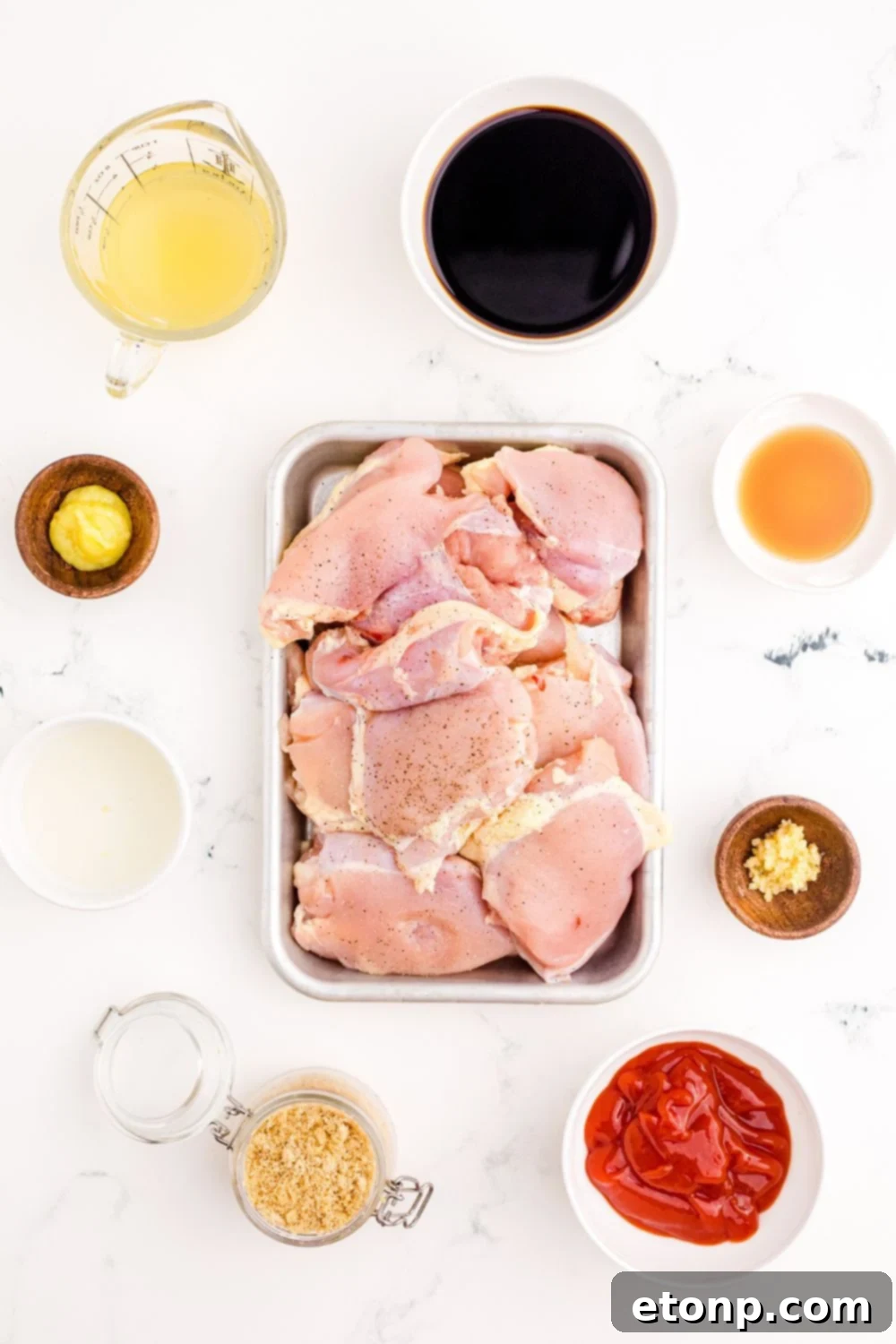 Fresh ingredients for Huli Huli Chicken including brown sugar, soy sauce, ginger, garlic, and chicken thighs, neatly arranged on a table