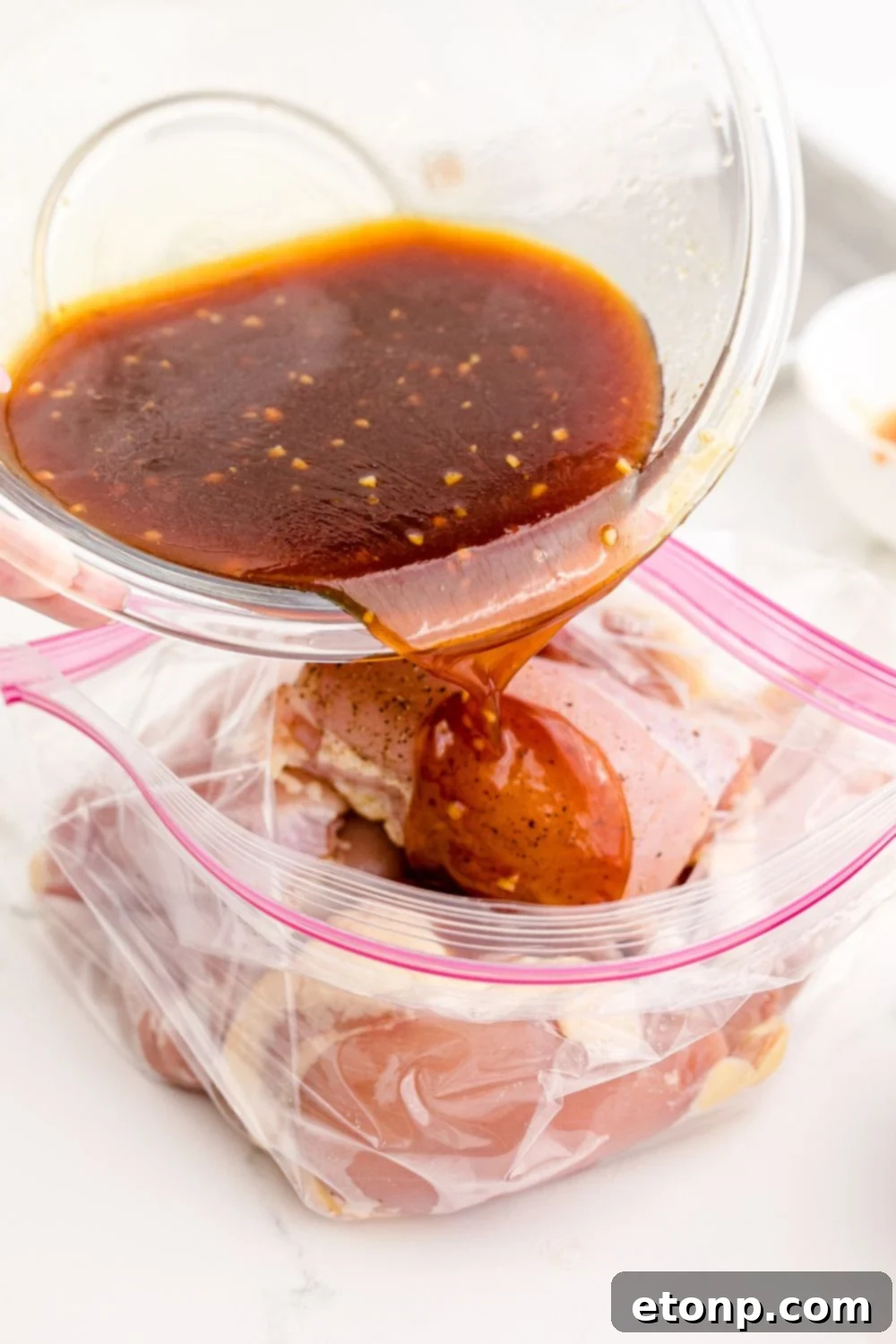 Pouring the delicious Huli Huli Chicken marinade over chicken pieces in a resealable bag for thorough coating