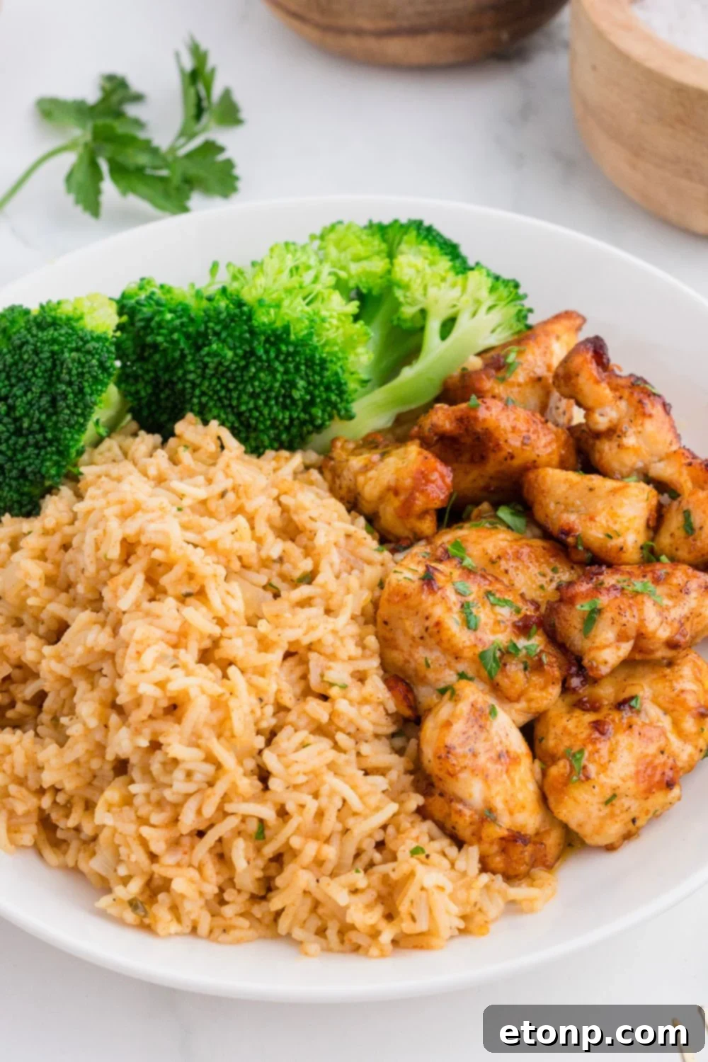 Buttery Garlic Chicken Bites 13 Garlic Butter Chicken Bites on plate with a pile of rice and broccoli on side of plate
