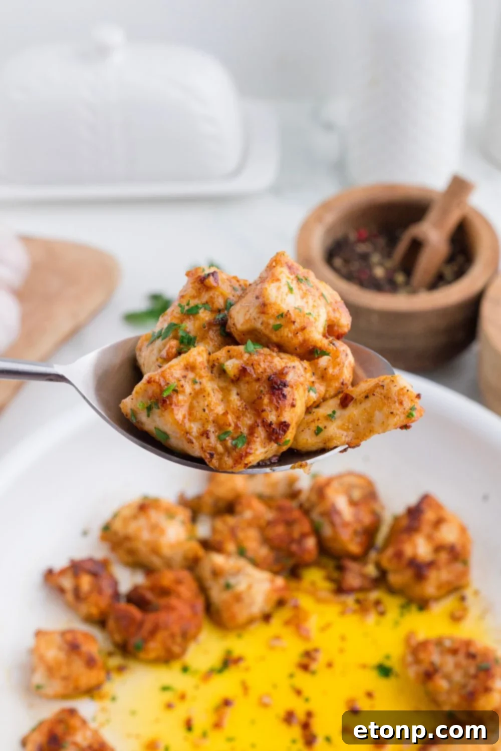 Buttery Garlic Chicken Bites 4 spoon with pieces of garlic butter chicken bites on it