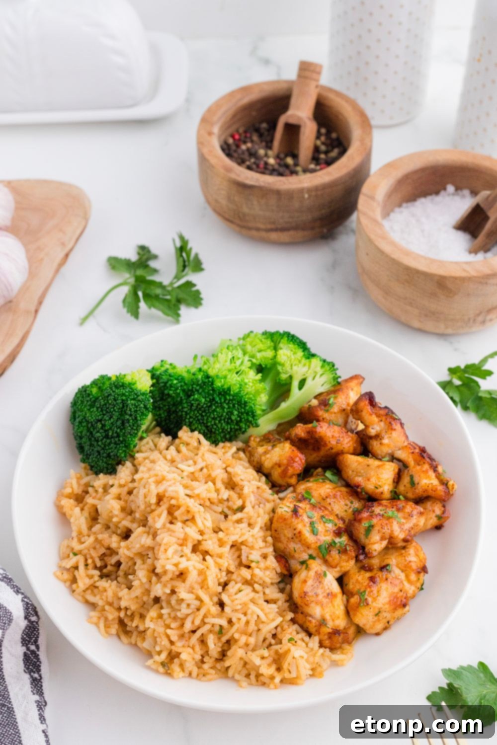 Buttery Garlic Chicken Bites 10 plate on table with Garlic Butter Chicken Bites , rice and broccoli on it