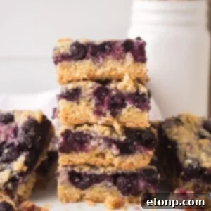 Blueberry Crumb Bars on table and a few stacked on top of each other