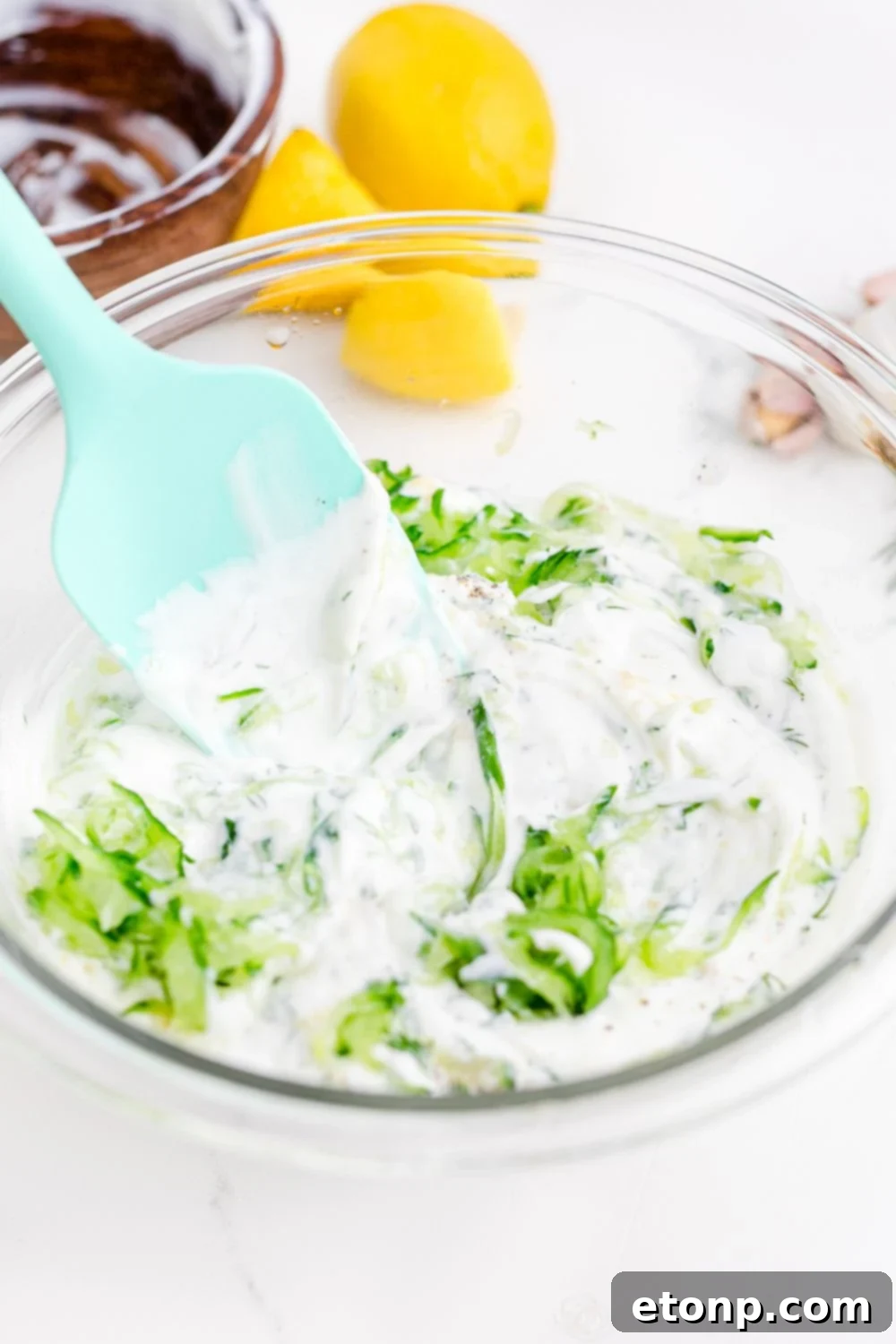 mixing up Tzatziki Sauce in a bowl 