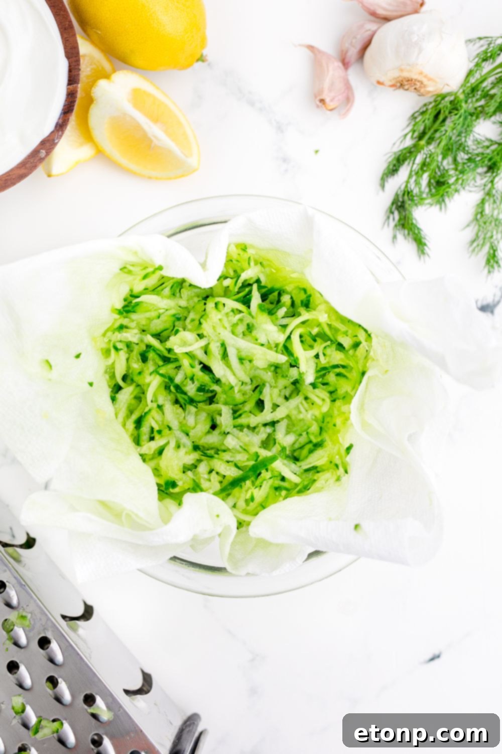 shredded cucumbers in a cheesecloth on table 