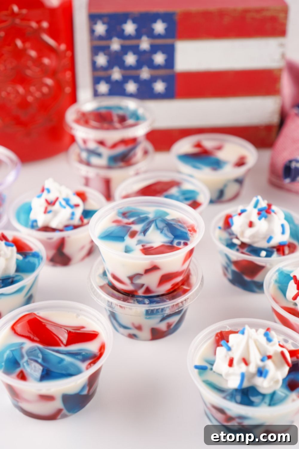 Red, White, and Blue Stained Glass Jello Shots stacked creatively on a table, showcasing their festive and appealing presentation.