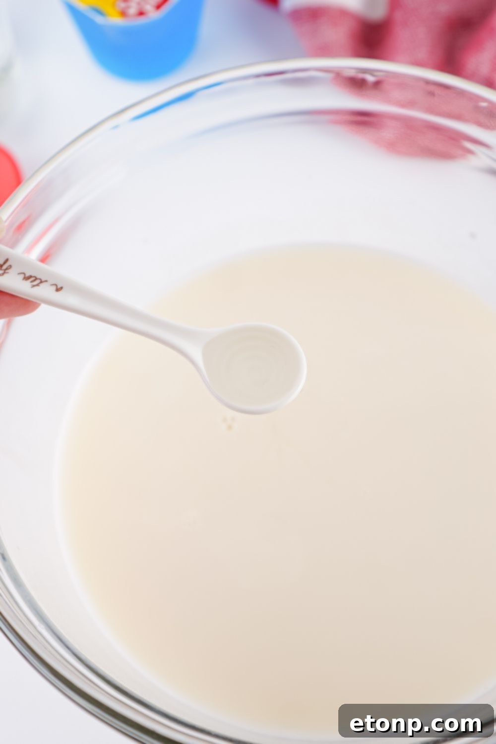 Creamy white jello mixture in a bowl, perfectly prepared for pouring into the stained glass jello shots.