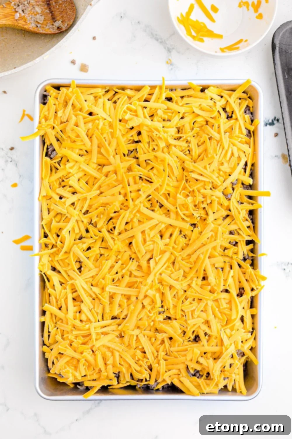A complete set of Hawaiian rolls, neatly sliced in half and carefully placed into a glass baking dish, forming a perfect foundation for building the delicious sliders.