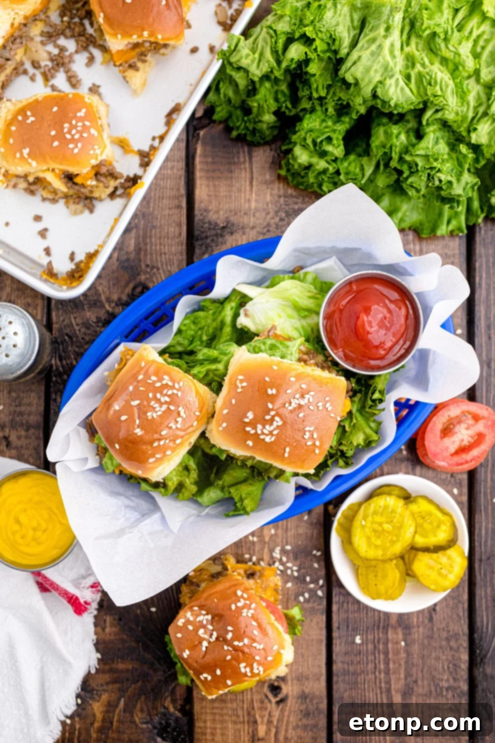 Classic Cheeseburger Sliders beautifully arranged in a rustic basket, accompanied by fresh lettuce and a small bowl of vibrant red ketchup, creating a simple yet inviting presentation.