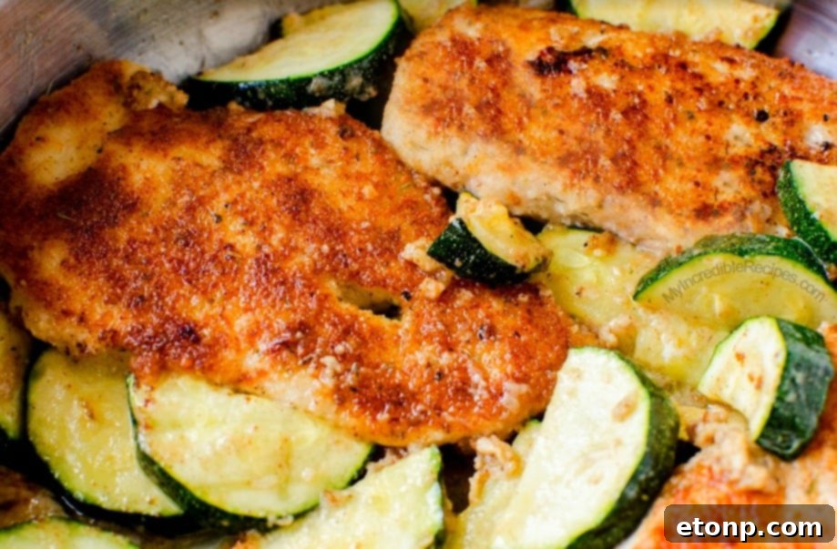 Crispy Parmesan Chicken and Garlicky Zucchini Skillet 2 Golden brown pan-fried Parmesan chicken and zucchini dish ready to serve