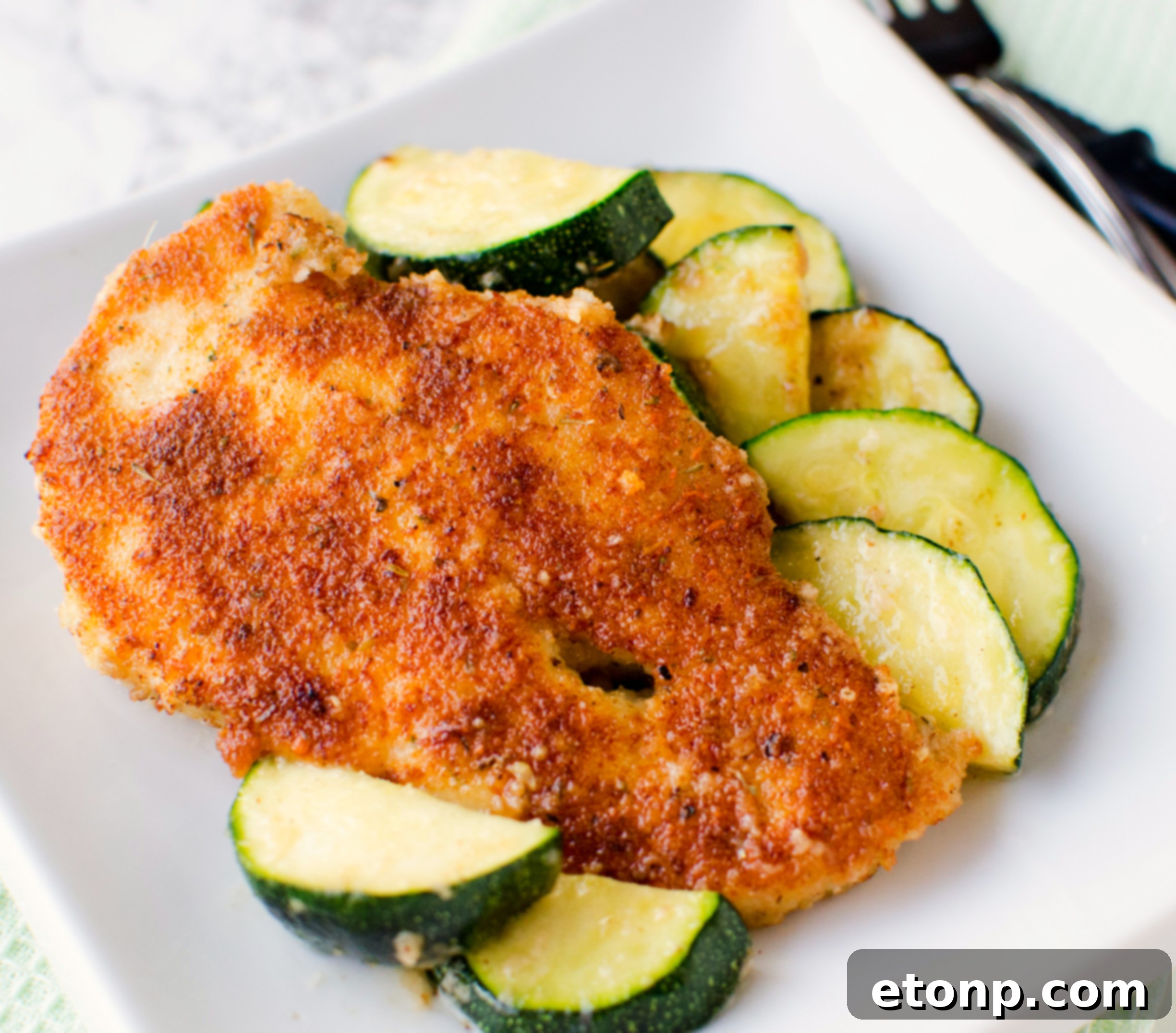 Crispy Parmesan Chicken and Garlicky Zucchini Skillet 3 Close-up of crispy pan-fried chicken breast with zucchini on a skillet