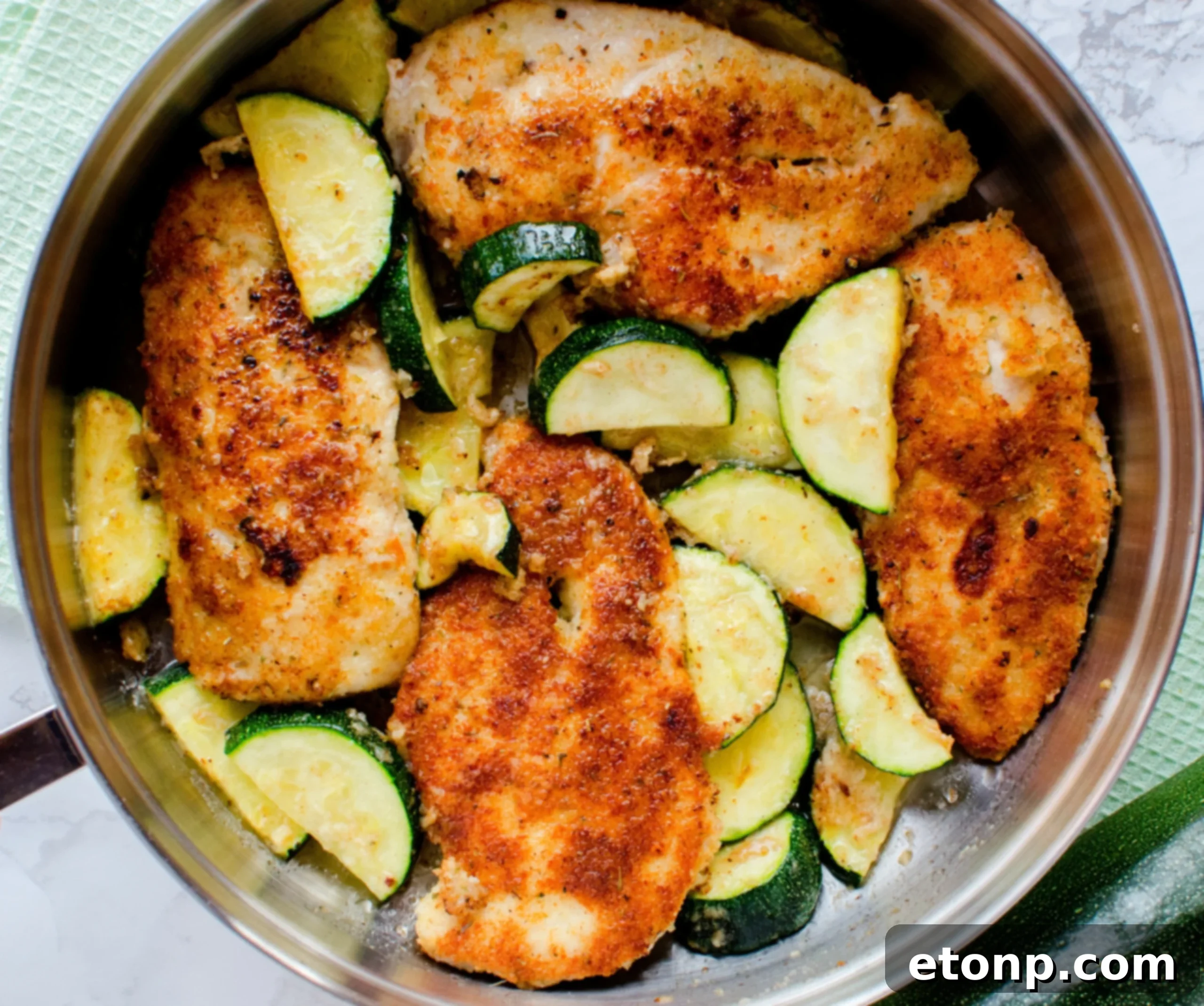 Crispy Parmesan Chicken and Garlicky Zucchini Skillet 7 Close-up of a serving of Pan-Fried Parmesan Chicken with a sprinkle of fresh herbs