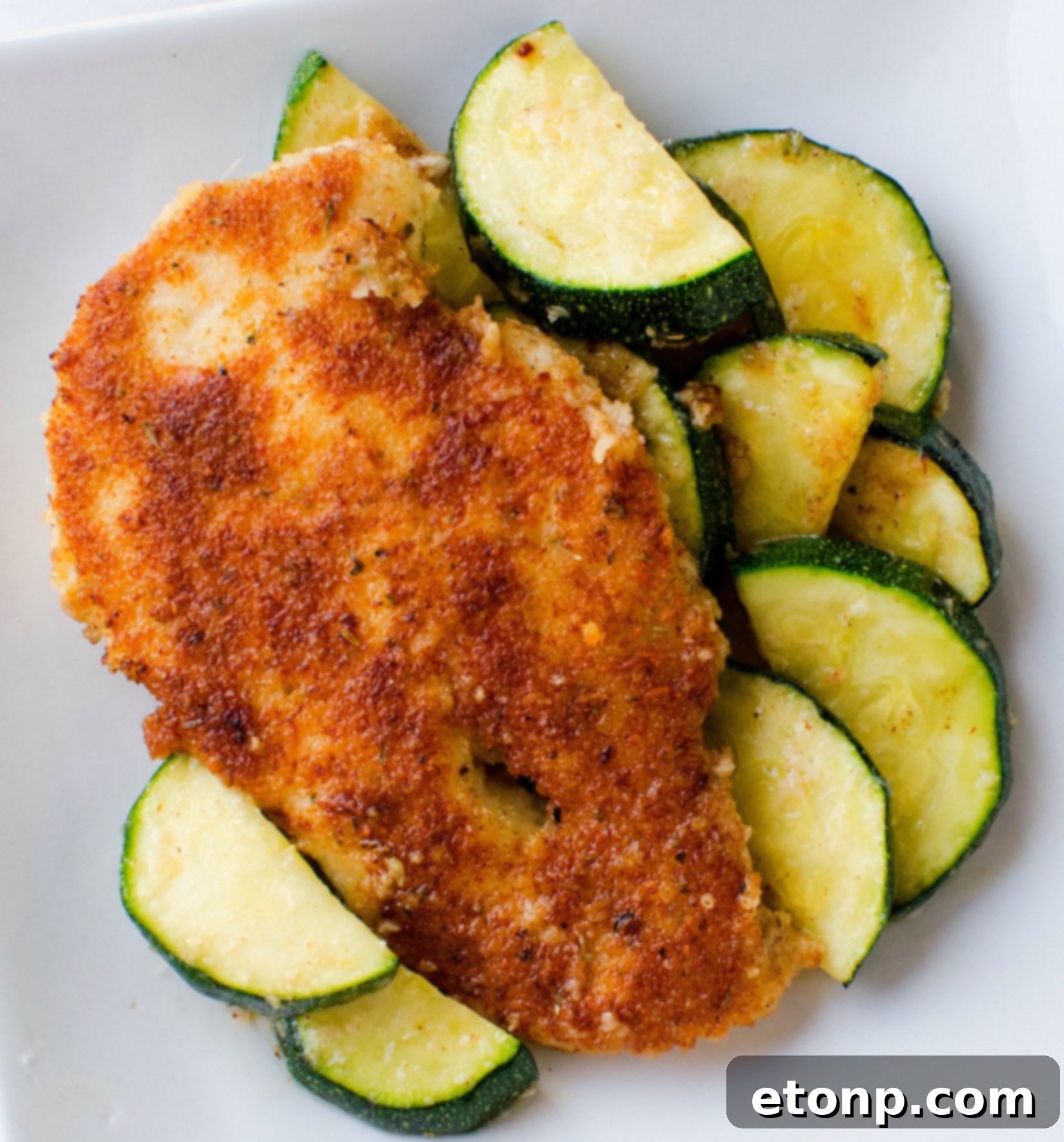 Crispy Parmesan Chicken and Garlicky Zucchini Skillet 10 Close-up of golden, crispy breading on a piece of Parmesan chicken