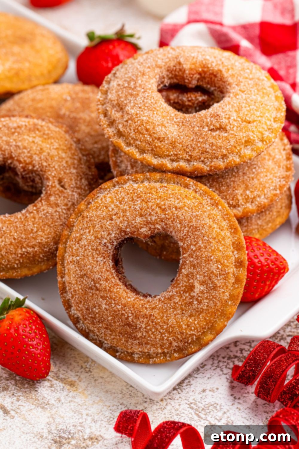 TikTok Fried Strawberry Uncrustables 12 A selection of Uncrustables on a plate, some with heart cutouts, surrounded by fresh strawberries on a rustic table