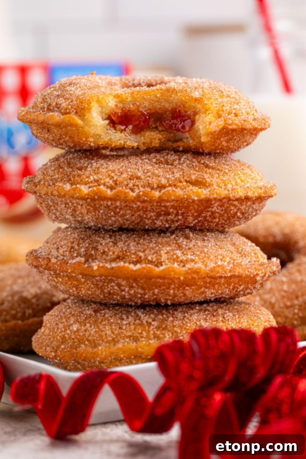 TikTok Fried Strawberry Uncrustables 13 Stack of fried Uncrustables on a plate, with a bite taken out of the top one to show the filling