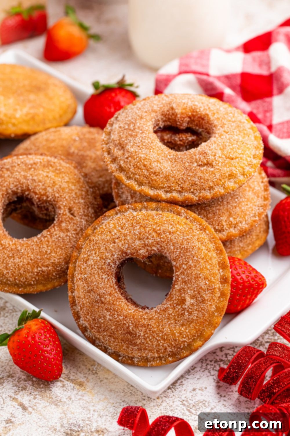 TikTok Fried Strawberry Uncrustables 18 Fried strawberry Uncrustables with heart cutouts neatly arranged on a tray, surrounded by strawberries and other red decorations