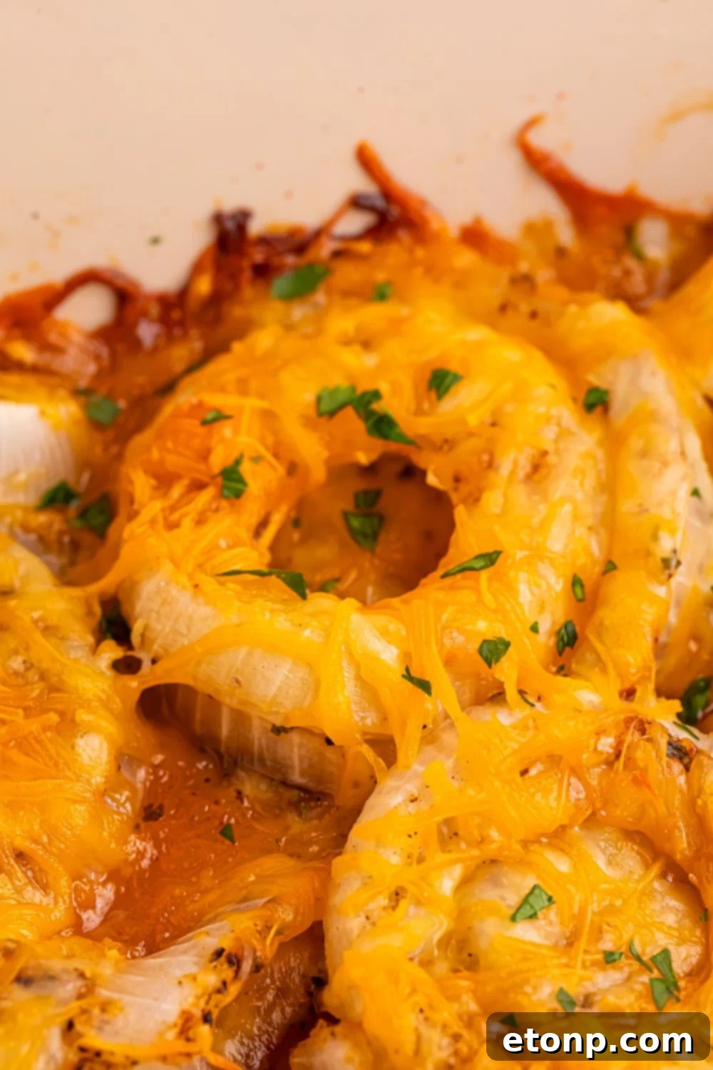 Cheesy Tennessee Onion Bake 15 Cheesy Tennessee Onions perfectly baked to a golden brown in a small pan, showcasing the crisp edges.
