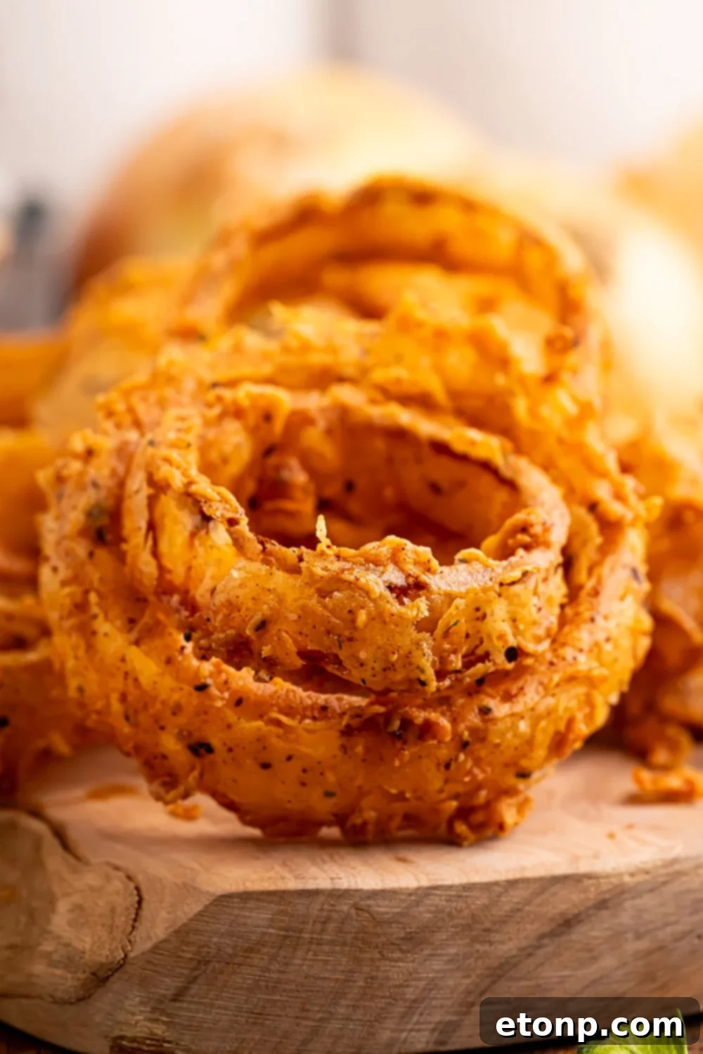 Golden Crispy Homemade Onion Rings 16 Homemade Deep Fried Onion Rings placed on top of one another on a tray