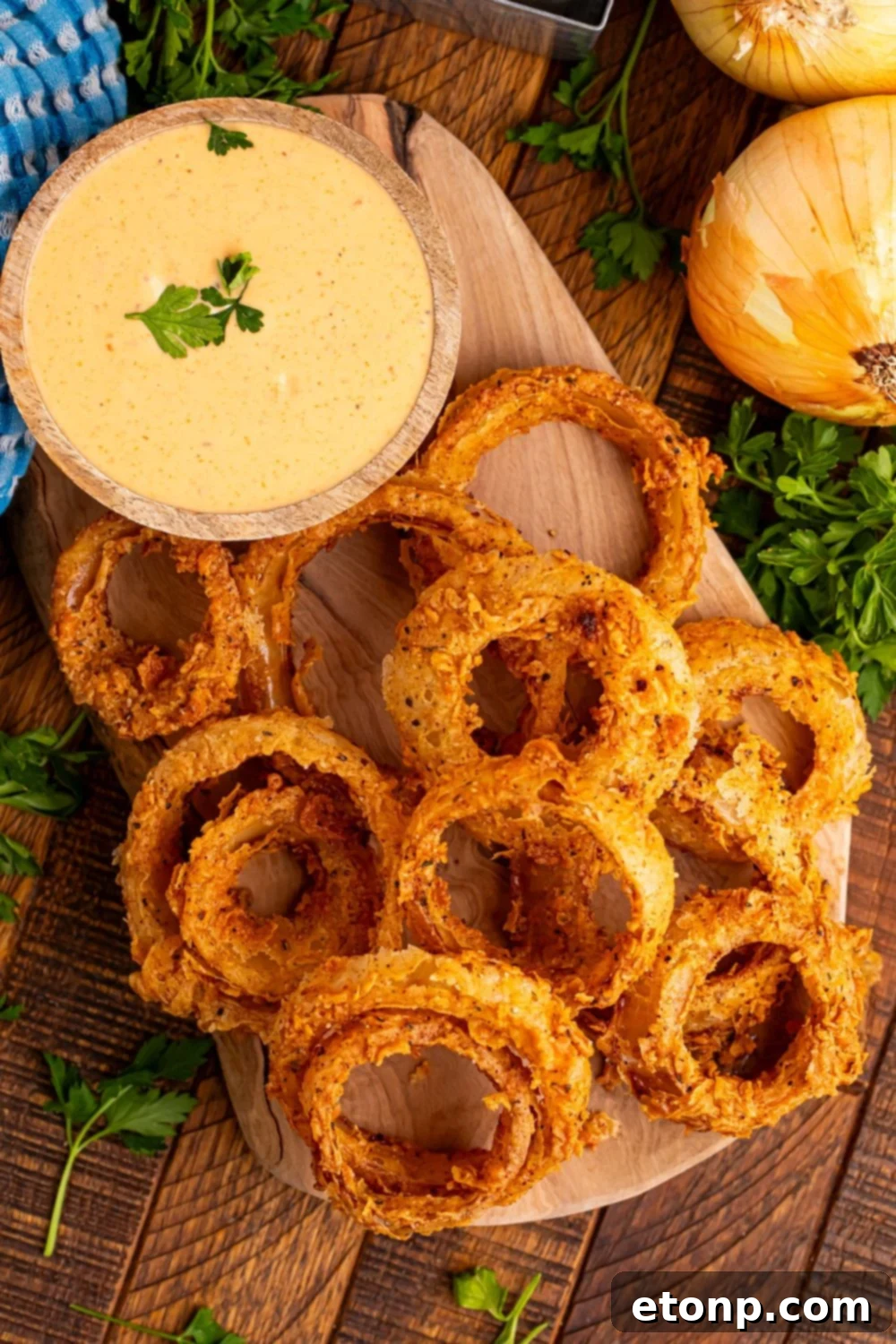 Golden Crispy Homemade Onion Rings 19 wooden table with a tray with onion rings on top of trya and a bowl of dip to side