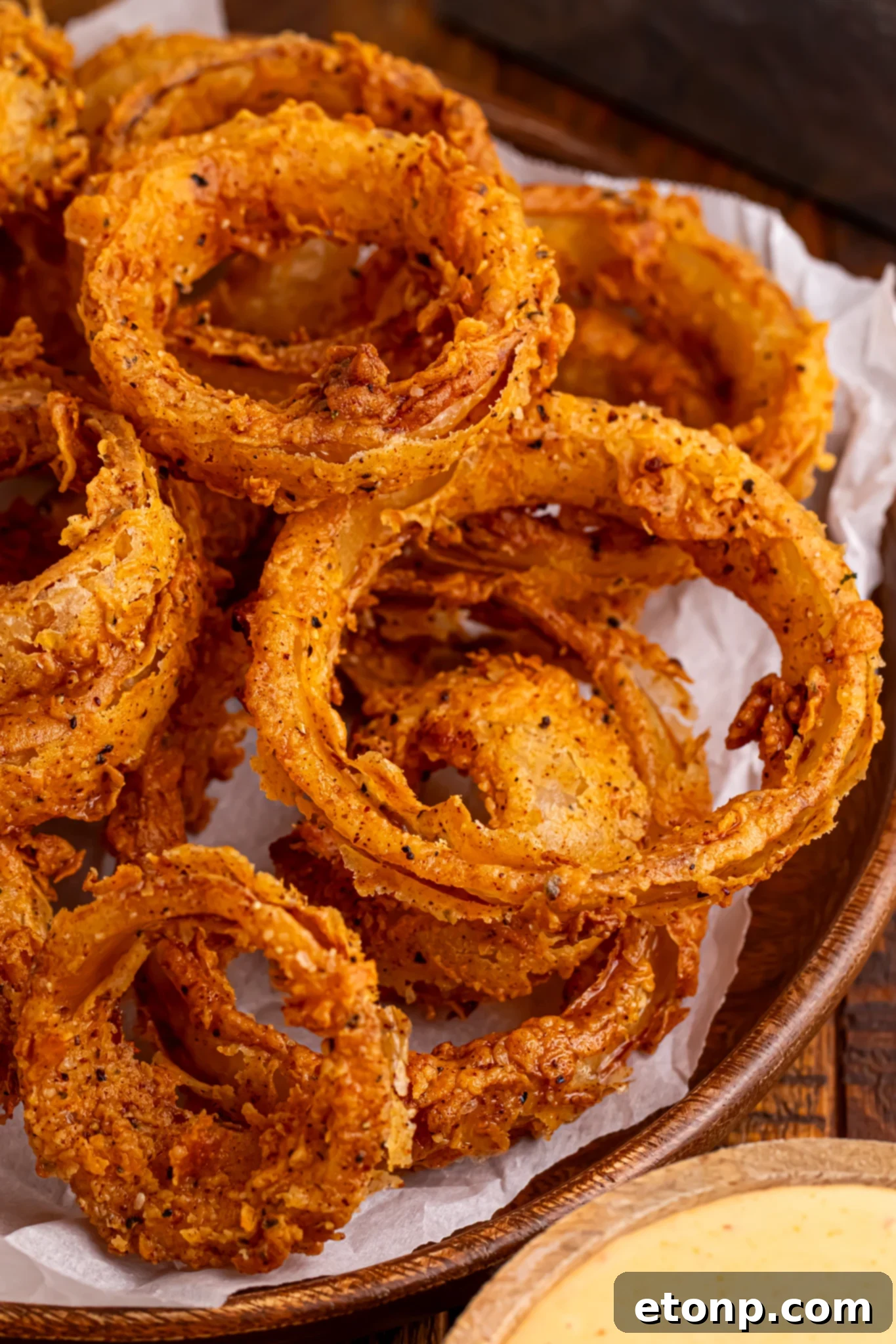 Golden Crispy Homemade Onion Rings 22 Homemade Deep Fried Onion Rings stacked on tray with parchment paper under the tray