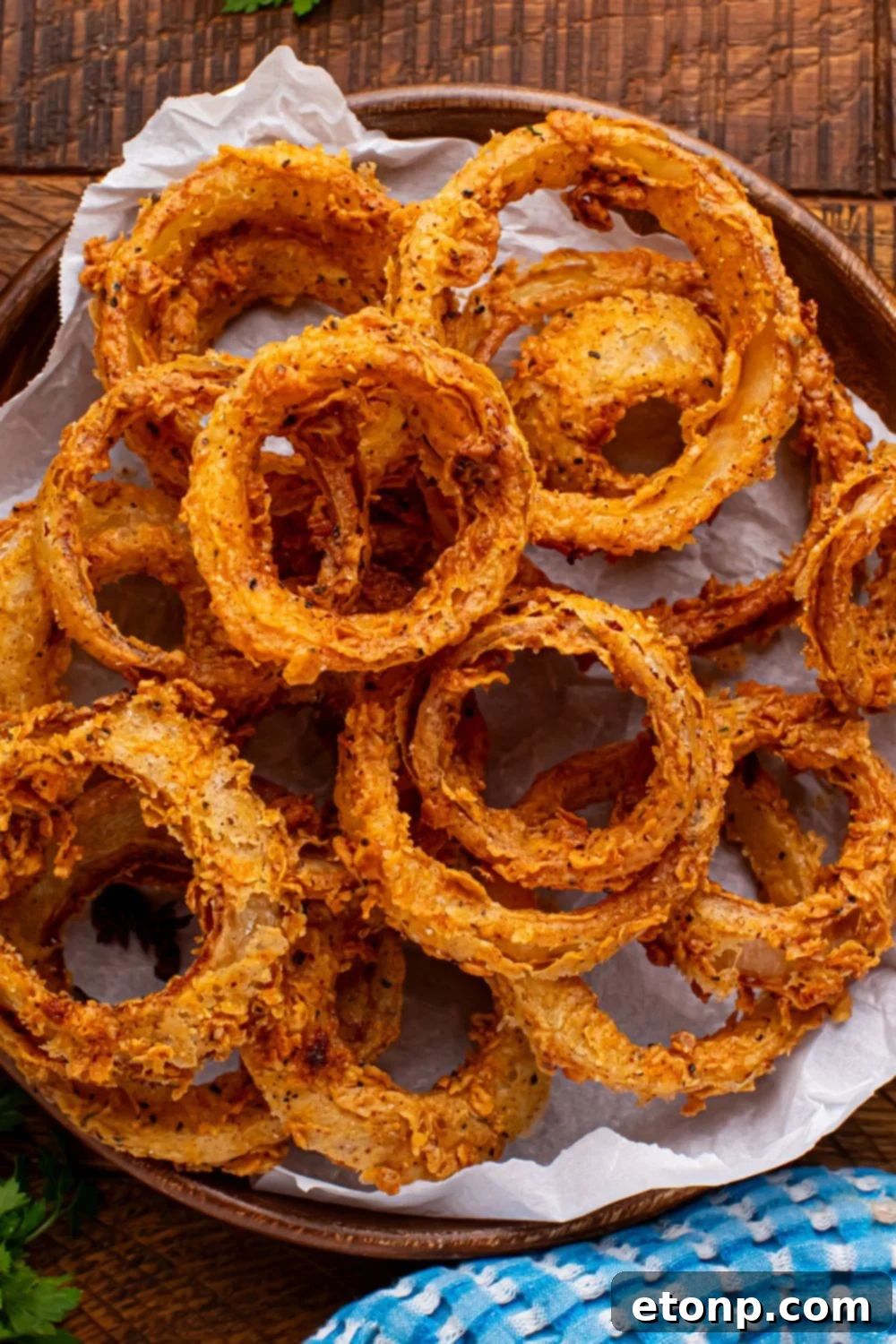 Golden Crispy Homemade Onion Rings 10 Homemade Deep Fried Onion Rings in a bowl with a towel to the side