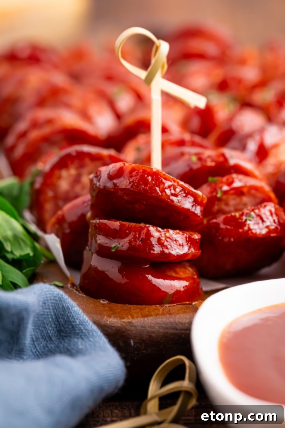 BBQ Hasselback Smoked Sausages on serving tray with one with a toothpick in it to show it is an appetizer 