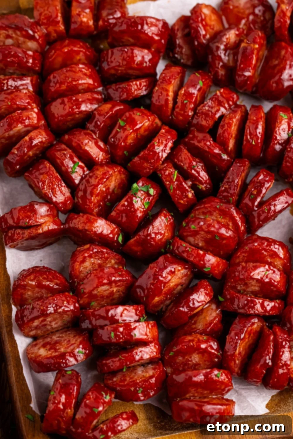 overhead view of BBQ Hasselback Smoked Sausages spread out with parsley sprinkled on top 