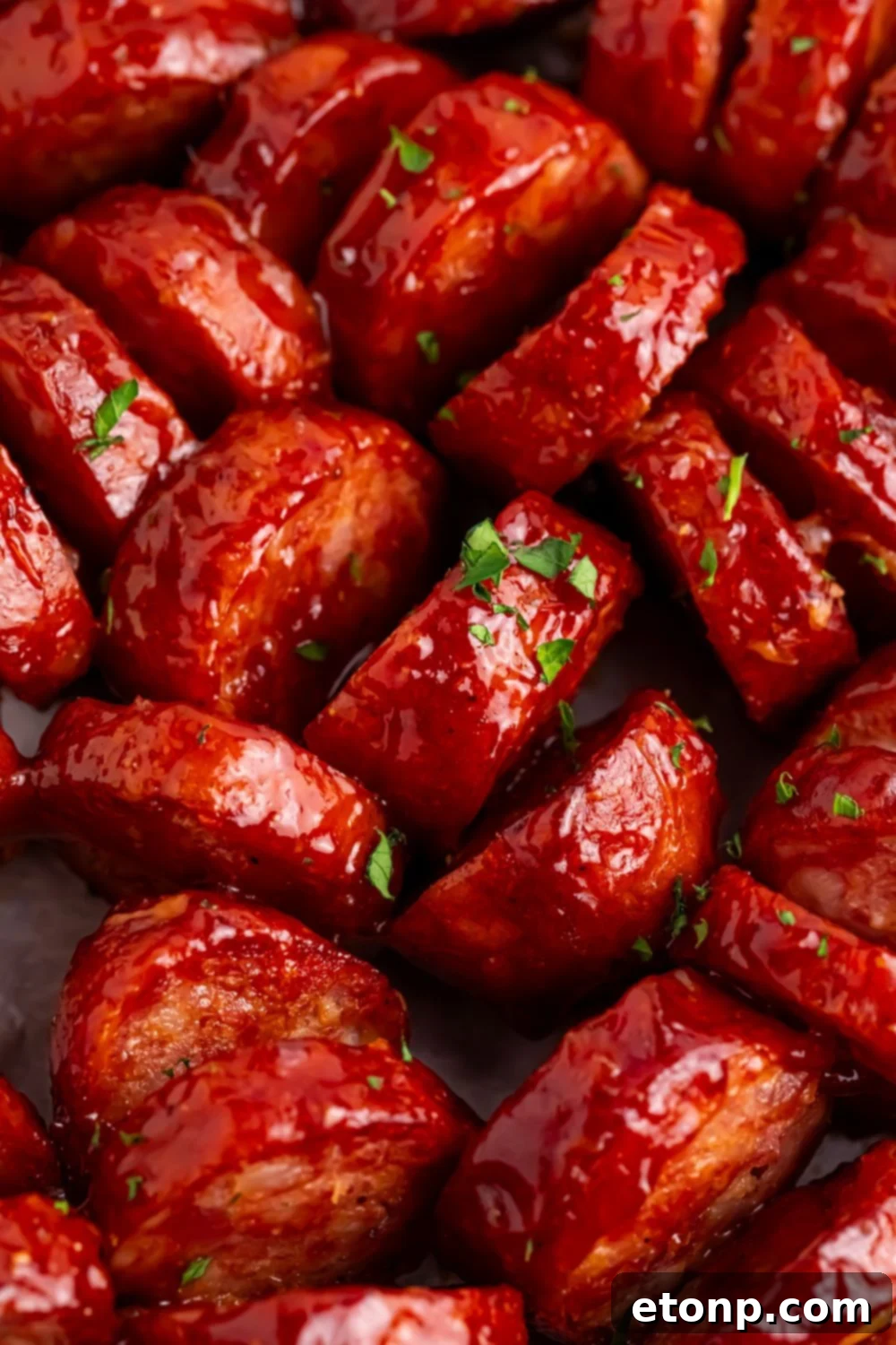close up of BBQ Hasselback Smoked Sausages with parsley sprinkled on top 
