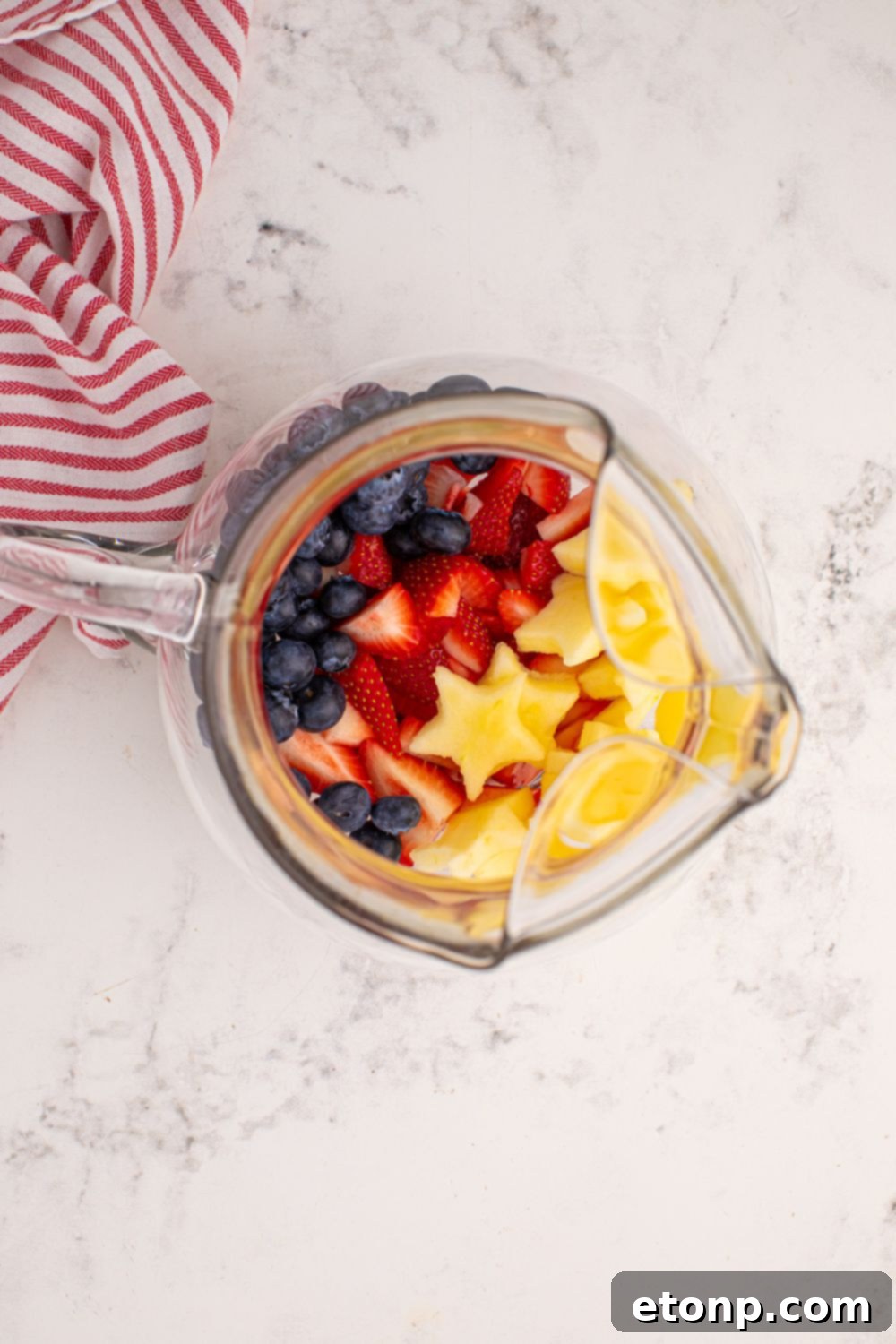 Liberty Lemon Sparkle 11 overhead look of pitcher with apples, blueberries, and strawberries