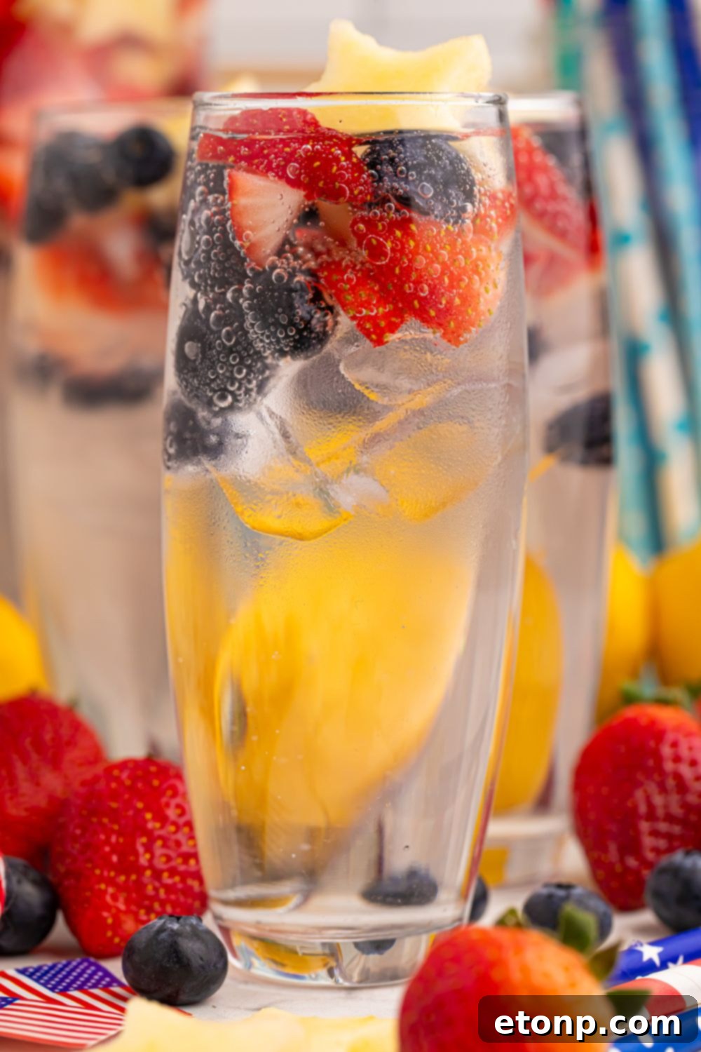Liberty Lemon Sparkle 23 Patriotic Sparkling Lemonade in glasses with fruit scattered on table to add a pop of color