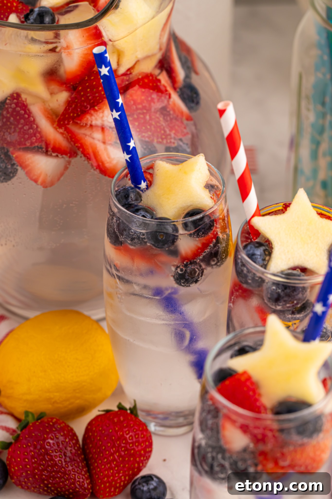 Liberty Lemon Sparkle 24 up close shot of the Patriotic Sparkling Lemonade in glasses with fruit scattered on table