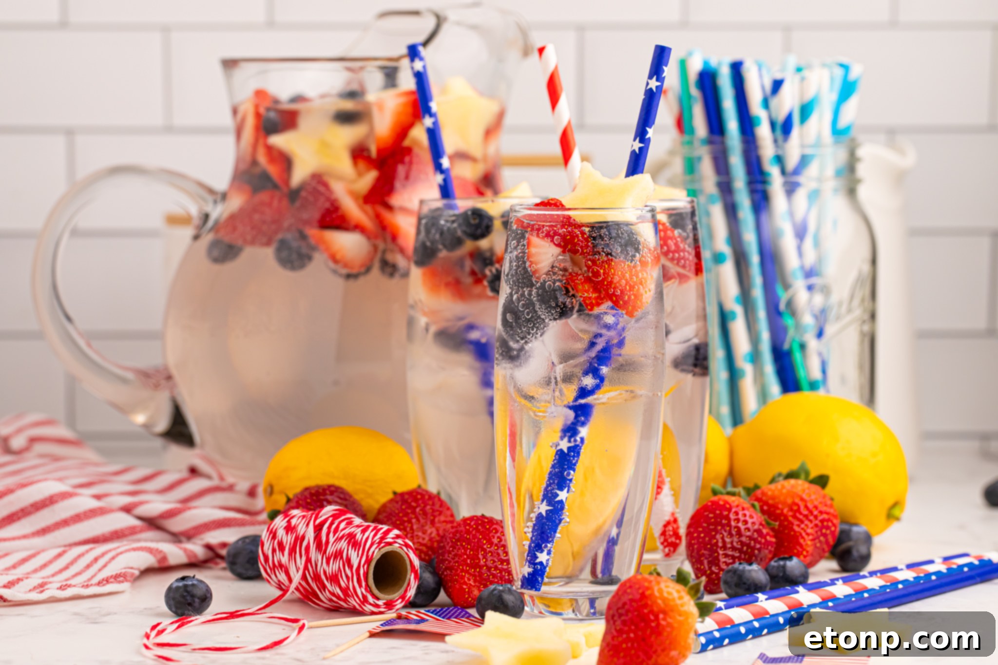 Liberty Lemon Sparkle 25 Patriotic Sparkling Lemonade in glasses with fruit scattered on table to add a pop of color