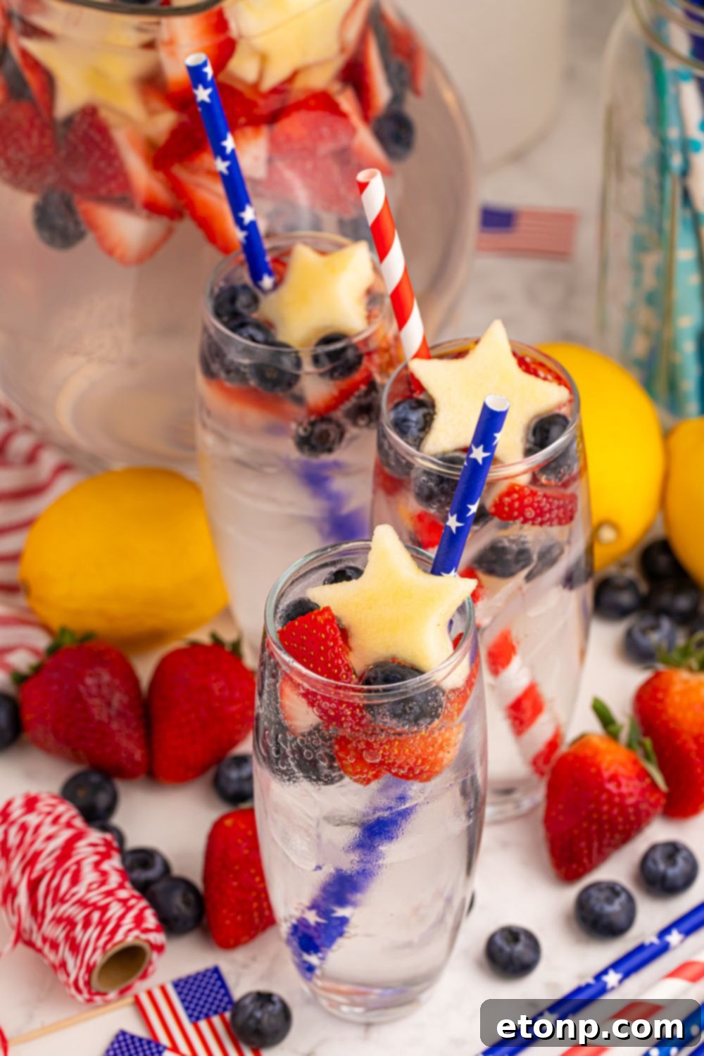 Liberty Lemon Sparkle 4 table with fresh fruit, and glasses of the Patriotic Sparkling Lemonade in it garnished with a fruit shaped like star and blue straws in each glass