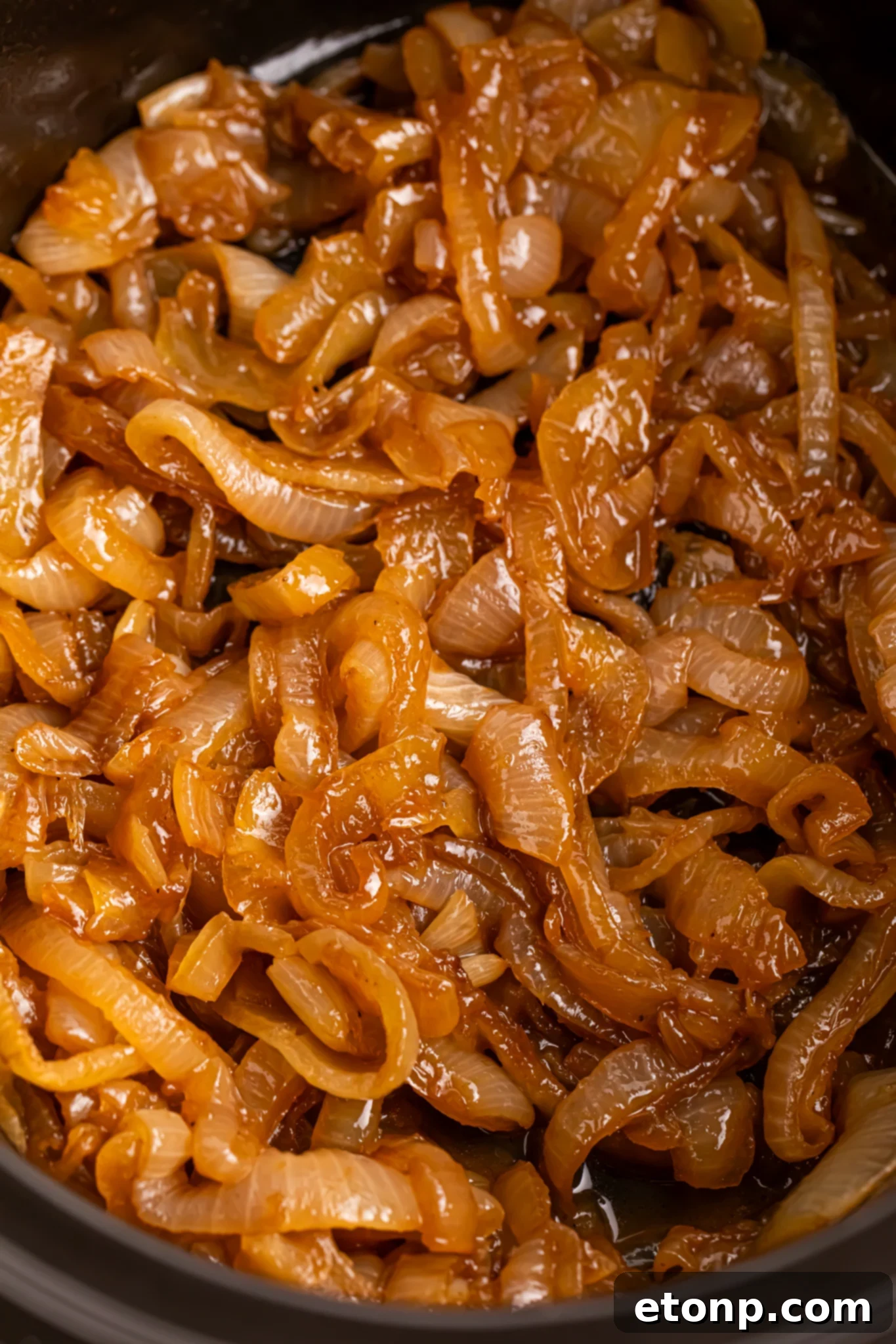 close of of the CrockPot Caramelized Onions in a black crockpot