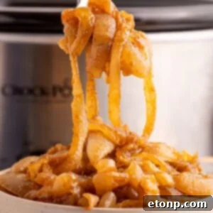 CrockPot Caramelized Onions in a bowl with the CrockPot behind it on table