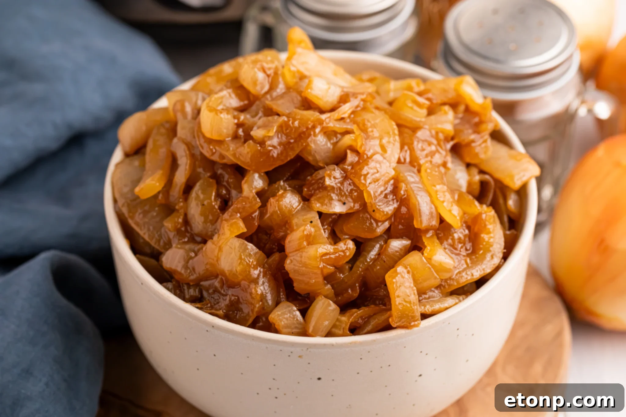 white bowl filled with CrockPot Caramelized Onions sitting on a table