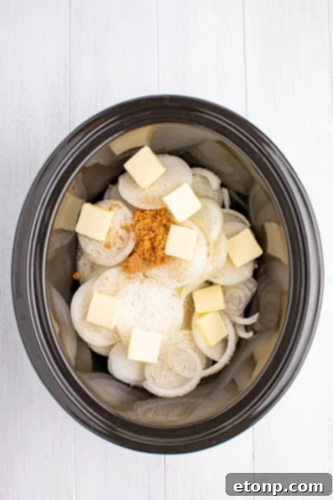 onions, brown sugar, butter and seasonings in a CrockPot on table for making Crockpot caramelized onions 