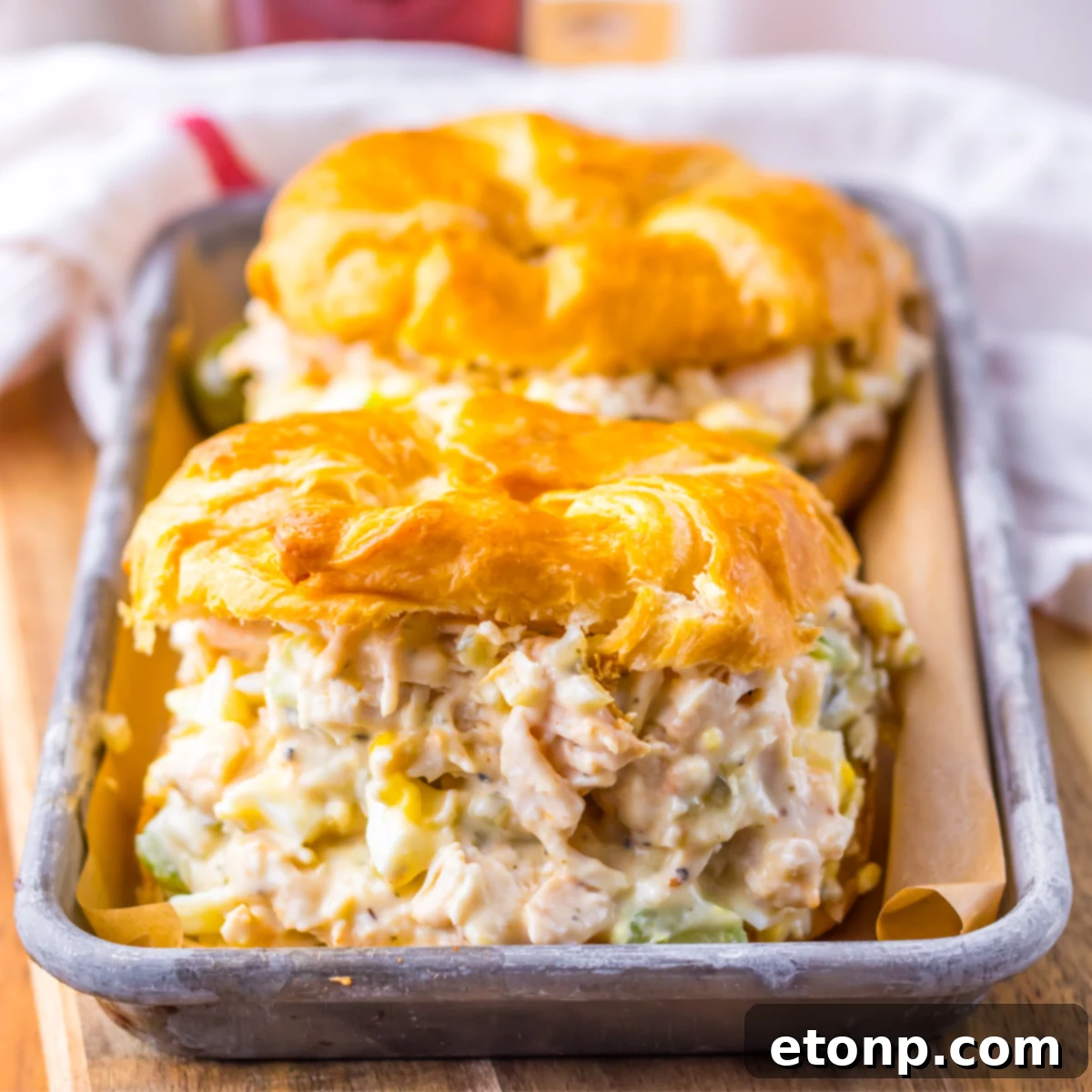 Side view of two chicken salad sandwiches on a tin tray.  