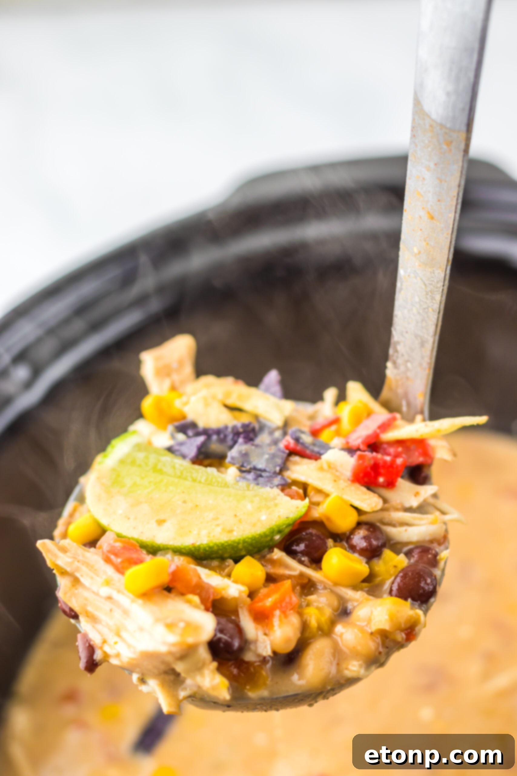 Slow Cooker Chick-Fil-A Tortilla Soup being lifting by a ladle
