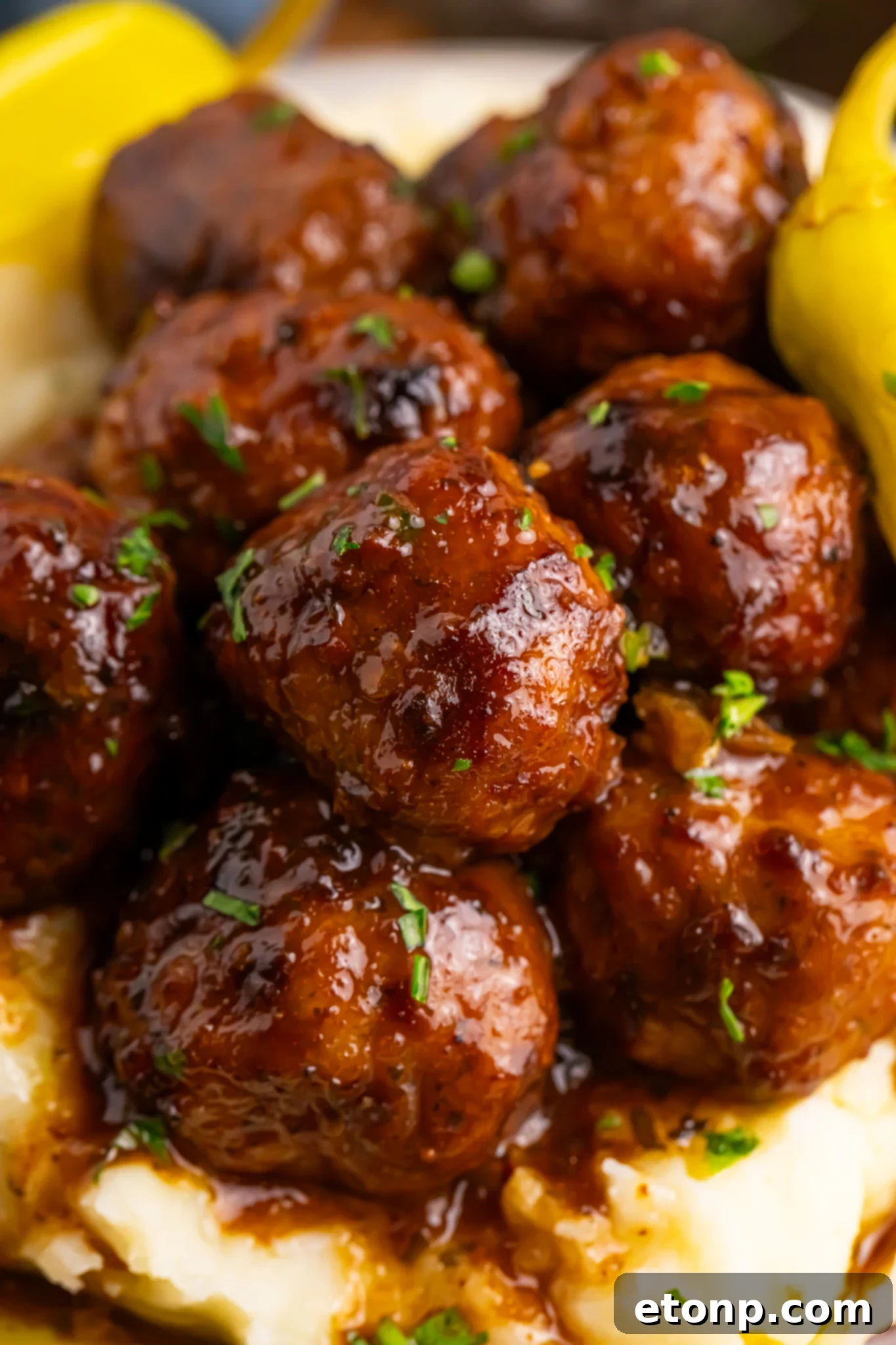 5 Ingredient Crockpot Mississippi Meatballs 17 Crockpot Mississippi Meatballs on a plate with mashed potatoes underneath a fork to the side on table