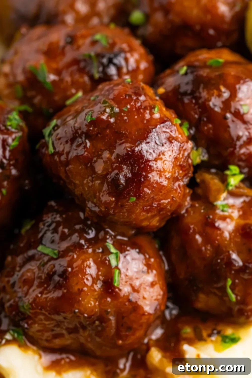 5 Ingredient Crockpot Mississippi Meatballs 22 close up of a stack of Crockpot Mississippi Meatballs on a plate on table with garnish