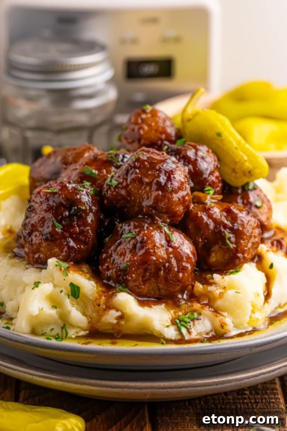 5 Ingredient Crockpot Mississippi Meatballs 7 plates stacked with Crockpot Mississippi Meatballs and mashed potatoes piled on a plate